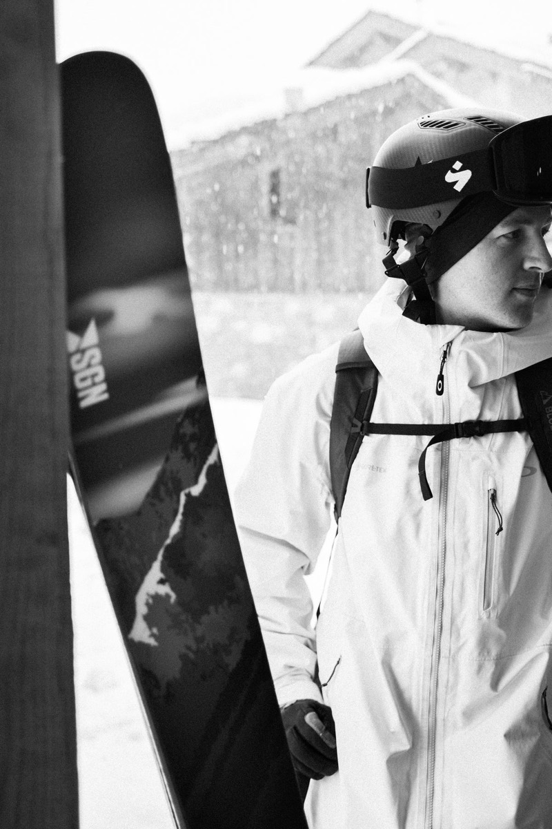 Skier holding SGN urRakkar skis in falling snow